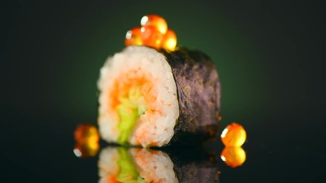 Sushi roll japaneese food rotated over black background. 4K UHD video footage. 3840X2160