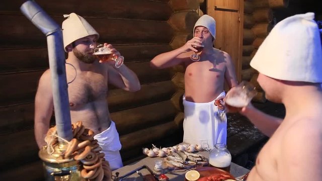 men drink beer in the russian bath