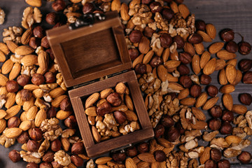 Wooden box full of nuts. Mix of hazelnuts, walnuts and almonds on the table