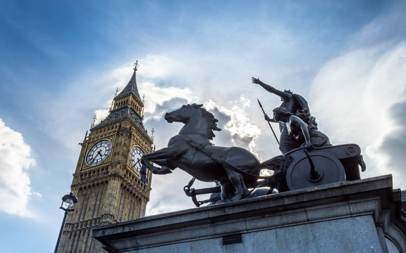 Big Ben, London, United Kingdom - A view of the popular landmark with the statue of Boadicea, the clock tower known as Big Ben against a blue and cloudy sky.