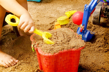 Close up of a child's hand playing sand toys.