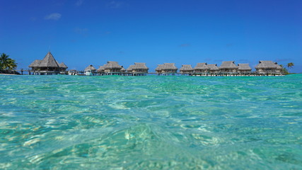 Tropical resort with thatched bungalows in the lagoon seen from sea surface, Tikehau atoll, Tuamotus, French Polynesia, Pacific ocean, Oceania