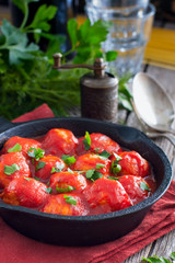 Meatballs in tomato sauce in a cast-iron frying pan, selective focus