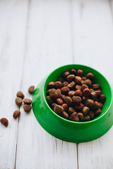 A bowl of dry dog food on a white board background. Pet care and veterinary concept. Space for your text or image