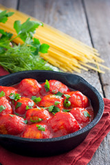 Meatballs in tomato sauce in a cast-iron frying pan, selective focus