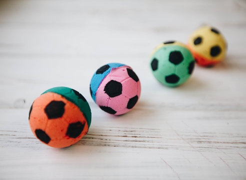 Colored Rubber Football Ball Toys For Pets On A White Board Background. Pet Care And Veterinary Concept