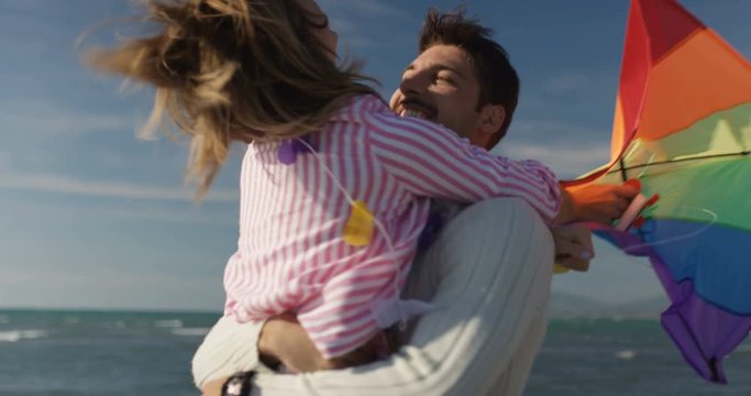 Happy coule having fun with kite on beach