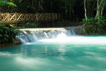 Scenic view on Kuang Si waterfall with turquoise water on a sunny day. Luangprabang, Laos.