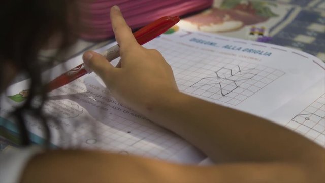 Young girl in summer camp doing homeworks outside outdoor in park under trees sitting on table slow motion