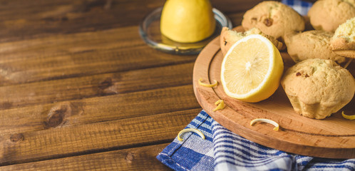 Lemon cupcakes on a wooden Board on the table with a blue towel.