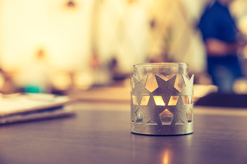 Teelicht mit Sternen in Cafe, Menschen im Hintergrund