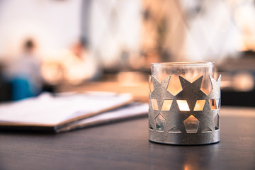 Teelicht mit Sternen in Cafe, Menschen im Hintergrund