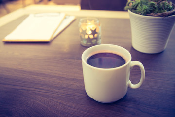 Teetasse mit Teelicht und Pflanze auf Holztisch. Konzept.