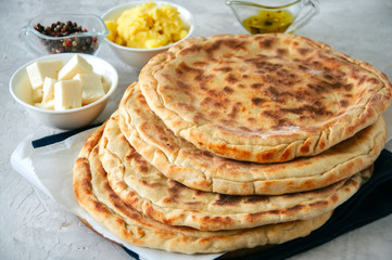 Mashed potato and sheep cheese filling flatbread on a white stone background.