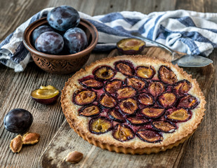 Homemade plum pie on the wooden background