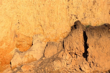 Close-up of a loamy ravine wall as an environmental texture background. Seaside coastal erosion with clay soil