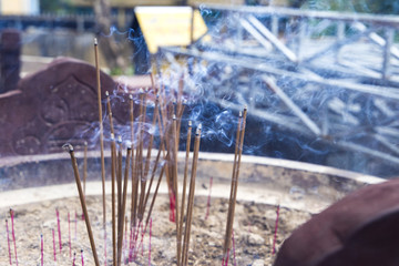 burning incense sticks in a special decorated bowl
