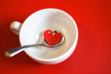 Red heart in a spoon. Copy space for text.