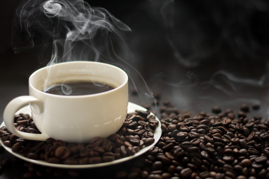 Hot cup of coffee with smoke on black background © thayra83