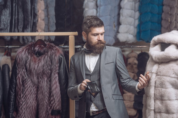 bearded man among fur, luxury, moneybags, business.