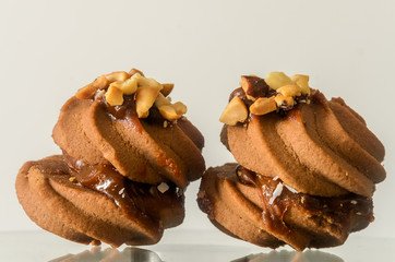 Biscuits with peanut nuts and milk cream on white background