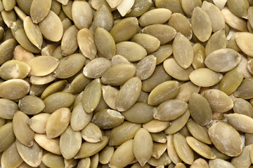 Organic Pumpkin seeds (Cucurbita pepo) in full frame background. Micro Closeup, Top view.