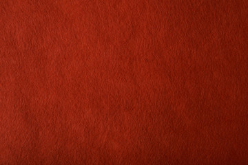 Fragment of the surface of fibrous synthetic non-woven material of red color. Background, texture