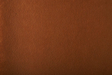 Fragment of the surface of fibrous synthetic non-woven material of orange color. Background, texture