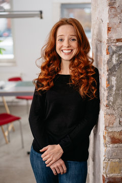 Amused young woman chuckling at the camera