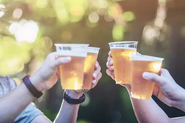 Foto op Plexiglas Celebration beer cheers concept - close up hands holding up glasses of beer of people group in outdoor party during their victory competition or successful task meeting © pairhandmade