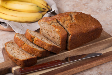 Sliced loaf of banana nut bread on a cutting board
