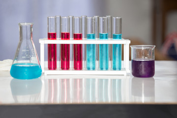 Red and blue liquid chemicals in tubes and beaker
