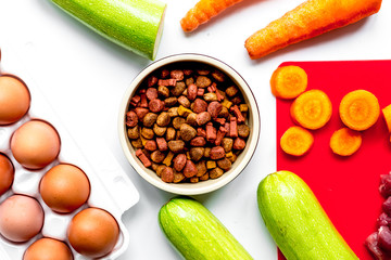 Dogfood set with vegetables, eggs and meat on table background t