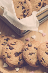 Valentine's day concept.. Chocolate chip cookies on rustic background with applied retro vintage style filters.