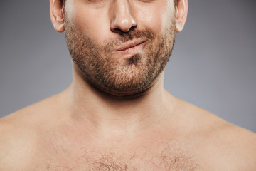 Obraz premium Cropped image of a young shirtless man grimacing