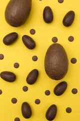 Chocolate easter eggs on a bright yellow background. Easter holiday concept