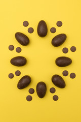 Chocolate easter eggs on a bright yellow background. Easter holiday concept