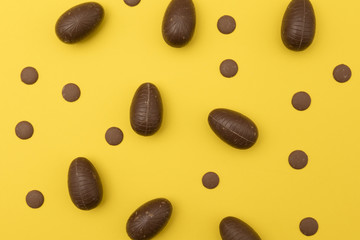 Chocolate easter eggs on a bright yellow background. Easter holiday concept