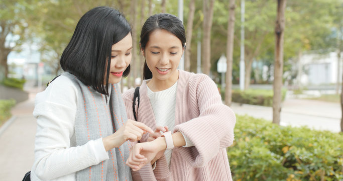 Friends finding shop location on smart watch at outdoor