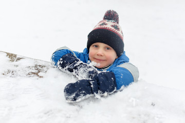 Fototapeta na wymiar Image of little boy in snow on park