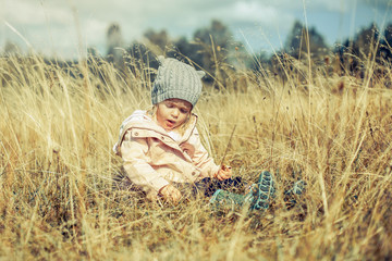 Naklejka na ściany i meble Little Girl Sitting on the Grass