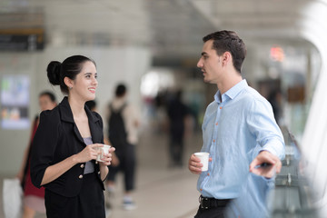 Two business colleagues in street city walk and talking to each other.