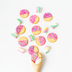 Delicious cookies with pink glaze and marshmallow in waffle cone on white background. Flat lay. top view.