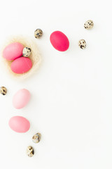 Easter pink egg and quail eggs in nest on white background, Top view, Fat lay. Easter holiday