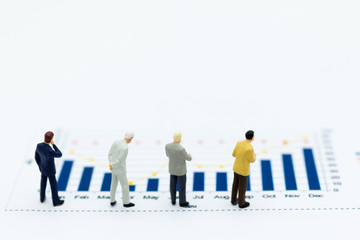 Miniature people: Businessman stand front of dashboard, display graphs, profit margins of  background. Image use for business concept.