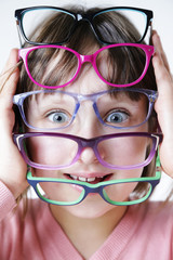 Dziewczynka trzyma kolorowe oprawki okularów.  © doroguzenda