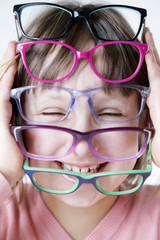 Dziewczynka trzyma kolorowe oprawki okularów.  © doroguzenda