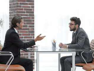 business partners talking while sitting at your Desk