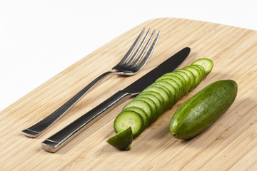 Green cucumbers on chopping board