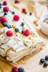 Homemade Meringue Almond Roll with Berries, Pistachios, Cream and Lemon Curd